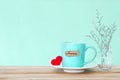 Coffee cup mug with red heart shapeand happy word tag on wooden