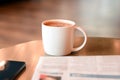 Coffee cup with newspaper and mobile phone on the table Royalty Free Stock Photo