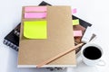 Coffee cup with notebook and blank yellow paper note on white t Royalty Free Stock Photo
