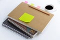 Coffee cup with notebook and blank yellow paper note on white ta Royalty Free Stock Photo