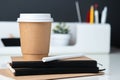 Coffee cup on notebook at modern office stationery on white table and dark grey wall.pencil,ruler,pen,pencil box and blackboard Royalty Free Stock Photo