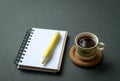 Coffee cup with notepad and pen on rustic black tabletop. Top view. Royalty Free Stock Photo