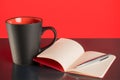 Coffee cup, open notebook and pen on black table Royalty Free Stock Photo