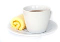 Coffee cup with orange cake roll.