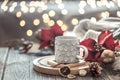 Coffee cup over Christmas lights bokeh in home on wooden table with flowers on a background and decorations. Holiday decoration, Royalty Free Stock Photo