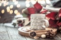 Coffee cup over Christmas lights bokeh in home on wooden table with flowers on a background and decorations. Holiday decoration Royalty Free Stock Photo