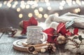 Coffee cup over Christmas lights bokeh in home on wooden table with flowers on a background and decorations. Holiday decoration, Royalty Free Stock Photo