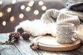 Coffee cup over Christmas lights bokeh in home on wooden table with sweater on a background and decorations. Holiday decoration Royalty Free Stock Photo