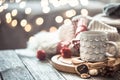 Coffee cup over Christmas lights bokeh in home on wooden table with sweater on a background and decorations. Holiday decoration, Royalty Free Stock Photo