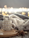 Coffee cup over Christmas lights bokeh in home on wooden table with sweater on a background and decorations. Holiday decoration Royalty Free Stock Photo