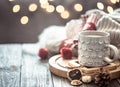 Coffee cup over Christmas lights bokeh in home on wooden table with sweater on a background and decorations. Holiday decoration Royalty Free Stock Photo