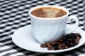 Coffee cup over dark roasted coffee beans Royalty Free Stock Photo