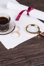 Coffee cup, paper sheets and detective magnifying glass