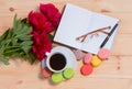 Coffee cup, pen, glasses, opened organizer and red peonies