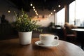 Coffee cup and plant adorn table in cozy coffee shop interior