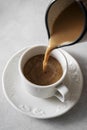 Coffee cup. Pouring milk in coffee ceramic white cup, morning hot drink. Lifestyle drink photo Royalty Free Stock Photo