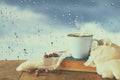 coffee cup on a rainy day over wooden table and window with rain drops background. Royalty Free Stock Photo