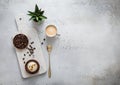Coffee cup with raw beans and golden spoon and caramell dessert on marble board