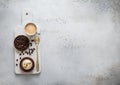 Coffee cup with raw beans and golden spoon and caramell dessert on marble board
