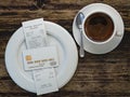 Coffee cup and receipt bill for payment by credit card on wooden table