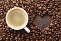 Coffee cup on roasted coffee beans and heart shaped frame Royalty Free Stock Photo