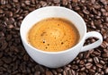 Coffee cup on roasted coffee beans as background