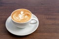 Coffee cup of rosetta latte art on wooden background with copy space