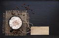 Coffee cup on rustic burlap and blank paper card. Top view with copyspace for your text. black background Royalty Free Stock Photo