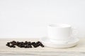 Coffee cup and saucer with coffee beans on wooden table Royalty Free Stock Photo