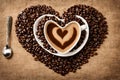 Coffee cup and saucer with heart, on a linen table, surrounded by coffee beans.. Royalty Free Stock Photo