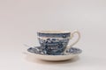 Coffee cup with saucer and teaspoon, patterned in blue tones, vintage style, on white background Royalty Free Stock Photo