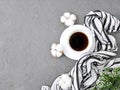 Coffee cup, scarf and cotton flowers on grey concrete background. Minimalist concept for feminine workplace or greeting card.