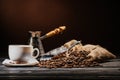 coffee cup with scoop and cezve on heap of coffee beans and on rustic