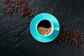 Coffee cup, shot from the top on a black slate background with coffee beans Royalty Free Stock Photo