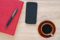 Coffee cup, smartphone and notebook on wood desk