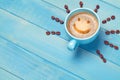 Coffee cup with smiley face on blue wooden table