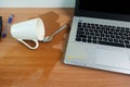 Coffee Cup spill out on Keyboard Laptop computer and smartphone on wooden floor Royalty Free Stock Photo