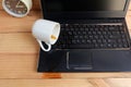 Coffee Cup spill out on Laptop Keyboard on wooden floor Royalty Free Stock Photo