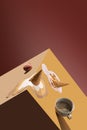Coffee cup with spilling coffee and melting ice cream in waffle cone over brown background. Creative collage. Minimal