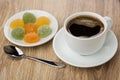 Coffee in cup, spoon and marmalade in saucer on table Royalty Free Stock Photo