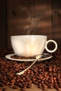 Coffee cup with spoon on roasted beans Royalty Free Stock Photo