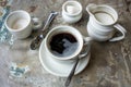 coffee cup with a spoon, sugar bowl, and creamer on side