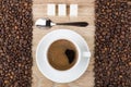 Coffee in cup, spoon, sugar on wooden table and beans Royalty Free Stock Photo