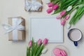 Coffee cup, spring tulip flowers and pink macarons on pastel table top view. Greeting for Womans or Mothers Day Royalty Free Stock Photo