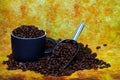 Coffee cup and steel scoop filled with coffee beans on grunge background Royalty Free Stock Photo