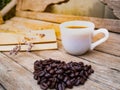 Coffee cup on the table and black rose coffeebean. heart shape bean on wooden table. afternoon refreshing drink for coffee lover.