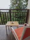 Coffee in cup on the table with seating at the balcony. Retro style