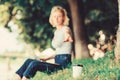 Coffee cup take away close up shot. Coffee cup on green grass woman worker with laptop defocused background. Coffee Royalty Free Stock Photo