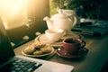 Coffee cup, tea pot ,cookies and laptop Royalty Free Stock Photo