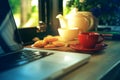 Coffee cup, tea pot ,cookies and laptop Royalty Free Stock Photo